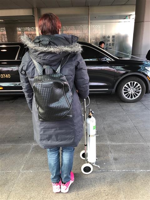 최근 폐 이식 수술을 받은 가습기 살균제 피해자 안은주씨가 같은 병원에서 투병하다 사망한 조모씨의 발인 차량을 바라보며 작별인사를 하고 있다. 사회적참사특조위 제공