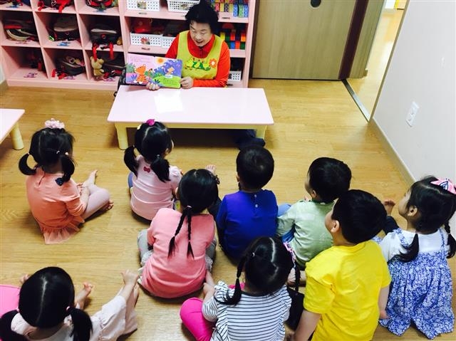 지난해 5월 관악구의 한 어린이집에서 ‘도란도란 그림책 읽기’에 참여한 지역의 한 어르신이 아이들에게 책을 읽어 주고 있다. 관악구 제공