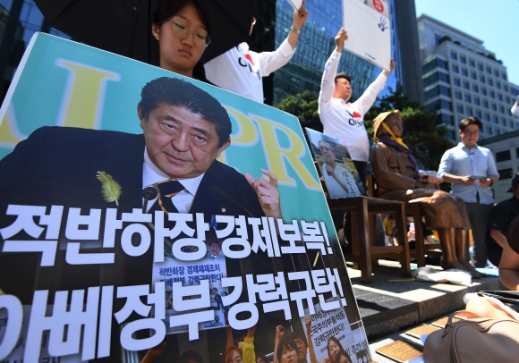 세계 일본군 위안부 기림일인 14일 오후 서울 종로구 옛 일본대사관 앞에서 열린 제1400차 일본군 성노예제 문제해결을 위한 정기 수요시위에서 한 참가자가 일본 아베정부의 경제 보복을 규탄하는 손피켓을 들고 있다. 2019.8.14 오장환 기자 5zzang@seoul.co.kr