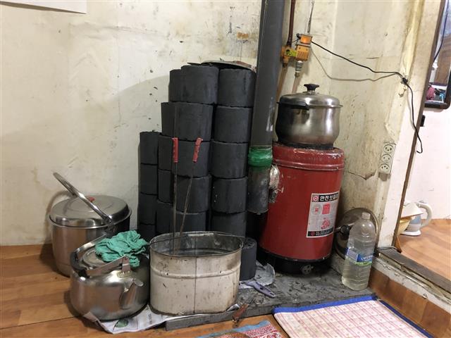 지난 13일 서울 불암산 기슭 백사마을의 한 가정집에 설치된 연탄난로의 모습. 연탄난로 옆에는 연탄 수십장이 수북이 쌓여 있다. 최영권 기자 story@seoul.co.kr