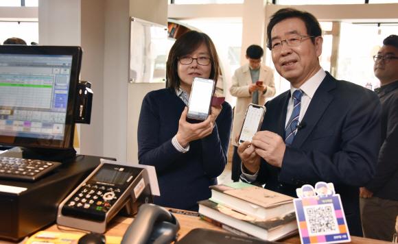 박원순(오른쪽) 서울시장이 지난 4월 종로구 역사책방에서 열린 ‘제로페이 10만호점 기념행사’에서 책을 구입한 후 제로페이로 결제하고 있다. 서울신문 DB