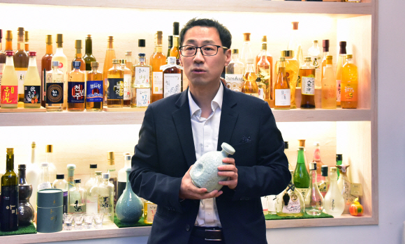 전통주 제조 박사인 이대형 농업연구사가 설 연휴를 앞둔 23일 서울 강남구 테헤란로에 있는 전통주 갤러리에서 전시된 전통주를 배경으로 포즈를 취하고 있다. 원래 인사동에 있던 전통주 갤러리는 지난해 강남역 근처로 이전했다. 이종원 선임기자 jongwon@seoul.co.kr