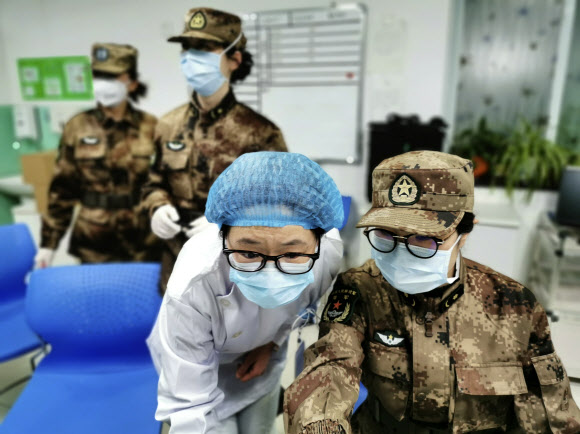 중국 인민해방군 소속 의료지원단원이 지난 26일 신종 코로나바이러스 진원지인 허베이성 우한시의 진인탄 병원 의료진에게서 업무를 넘겨받고 있다. 우한 신화 연합뉴스