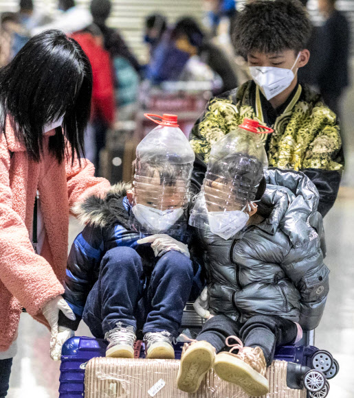 어린이들이 1일(현지시간) 중국 광둥성 광저우 공항 입국 터미널에서 코로나 바이러스로부터 보호하기 위해 물병으로 만든 즉석 얼굴 보호 장치를 착용하고 있다. EPA 연합뉴스