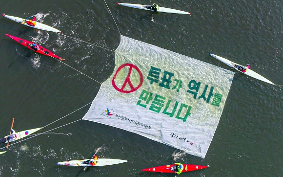 제21대 국회의원선거를 한 달 앞두고 15일 부산 해운대 센텀시티 옆 수영강에서 카약 동호인들이 부산시선거관리위원회와 공동으로 투표 참여를 호소하는 퍼포먼스를 하고 있다. 2020.3.15 부산시선관위 제공.