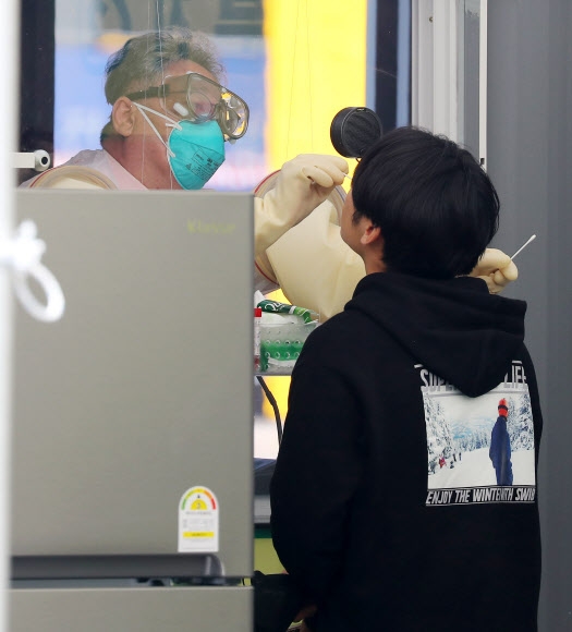3일 오후 서울 송파구 잠실종합운동장에 마련된 워크스루 방식 선별진료소에서 한 시민이 검체채취를 받고 있다. 서울시는 3일부터 서울 거주 입국자들에 대해 전원 검사를 실시한다. 서울 거주 입국자는 공항에서 발열 체크를 거친 뒤 유증상자는 인천공항 선별진료소에서, 무증상자들은 잠실종합운동장에 마련된 해외입국자 전용 워크스루 선별진료소 또는 해당보건소에서 진단검사를 받는다. 2020.4.3 연합뉴스