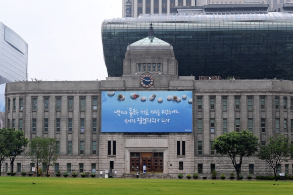 덕수궁과 이웃한 경성부청사(현 서울시청 서울도서관). 대지의 모양을 따라 활같이 휘게 배치했고 지층부의 거친 돌다듬(러스티케이션)으로 장식했다.