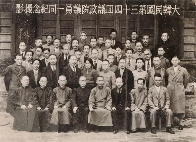 대한민국임시정부는 1942년 좌우합작 정부를 이뤘다. 맨 앞줄 왼쪽 네 번째가 한국독립당 소속인 홍진 임시의정원 의장이며 그 오른쪽이 김구 임시정부 주석이다. 앞줄 오른쪽 끝에 앉은 이가 조선민족혁명당의 김원봉이다. 임시의정원 의원 전원이 제34회 정기의회 개원 기념으로 사진을 촬영했다. 국사편찬위원회 제공