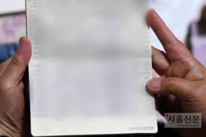 한 노인이 통장을 보고 있는 모습.  오장환 기자 5zzang@seoul.co.kr