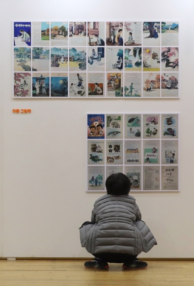 지난 16일 경기 파주출판도시에서 진행한 ‘BOOK(北) 읽는 풍경 전시회’에서 한 어린이가 북한 어린이책을 바라보고 있다. 동아일보 제공