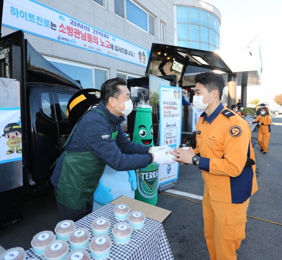 김인규 하이트진로 사장이 3일 경북 경주소방서에 진행된 ‘감사의 간식차’ 행사에 참석해 소방대원들에게 간식을 나눠주고 있다/하이트진로 제공