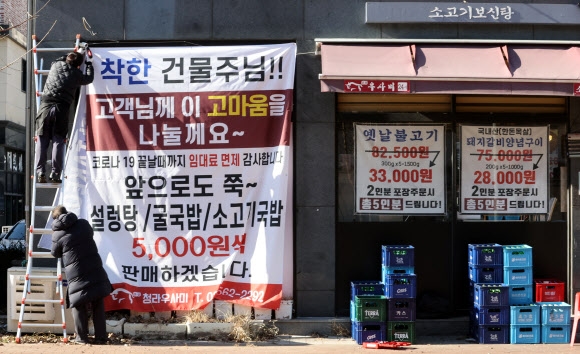지난해 12월 인천시 서구 청라동 한 음식점 앞에서 임대료를 감면받은 점주가 ‘임대인 감사’ 현수막을 부착하고 있다. 연합뉴스