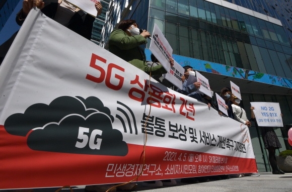 5일 서울 sk텔레콤 본사앞에서 열린 5G 불통 보상 및 서비스 개선 촉구 기자회견에 참석한 민생경제연구소 소속 회원들이 피켓을 들고 있다. 2021.4.5 박지환기자 popocar@seoul.co.kr