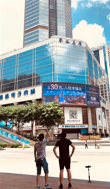 지난 22일 ‘싸이거광장’ 앞에서 시민 두 명이 동영상을 촬영하며 건물을 살펴보고 있다.