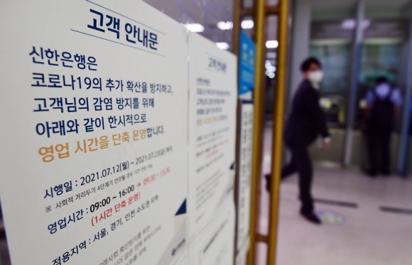 코로나19 사회적 거리두기 최고단계인 4단계가 본격 적용된 12일 서울 중구 신한은행 파이낸스센터점에 영업시간 단축 운영 안내문이 붙어있다.2021. 7. 12 박윤슬 기자 seul@seoul.co.kr