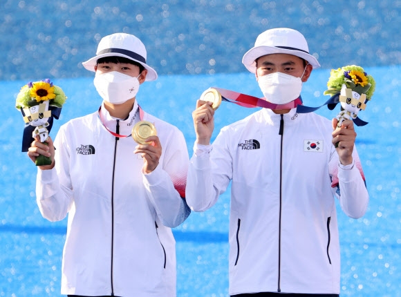 24일 일본 도쿄 유메노시마 공원 양궁장에서 열린 도쿄올림픽 양궁 혼성 결승전에서 금메달을 획득한 양궁 국가대표 김제덕과 안산이 금메달을 목에 걸고 포즈를 취하고 있다. 2021.7.24  연합뉴스