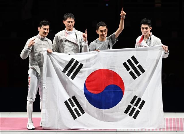오상욱, 구본길, 김정환, 김준호가 28일 일본 지바의 마쿠하리 메세에서 열린 2020도쿄올림픽 펜싱 남자 사브르 단체전 결승에서 이탈리아를 꺽고 우승을 확정한 뒤 태극기를 들고 포즈를 취하고 있다. 2021.07. 28. 지바=올림픽사진공동취재단