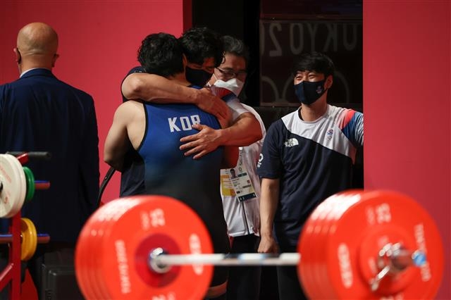 대한민국 역도 국가대표 진윤성 선수가 3일 일본 도쿄 국제 포럼 경기장에서 열린 2020도쿄올림픽 역도 남자 109kg급 출전을 마치고 코치들과 포옹하고 있다. 진 선수는 용상 3차시기에 실패했다. 2021.08.03 도쿄=올림픽사진공동취재단