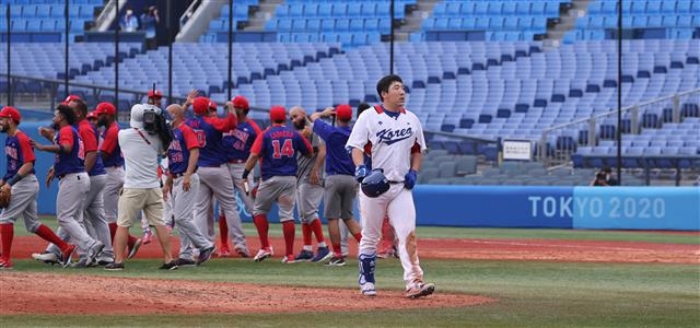 한국 야구 대표팀 주장 김현수가 지난 7일 일본 요코하마 야구장에서 열린 도쿄올림픽 야구 도미니카공화국과의 동메달 결정전에서 패한 뒤 기뻐하는 도미니카공화국 선수들을 뒤로한 채 허탈한 표정으로 경기장을 빠져나오고 있다. 요코하마 올림픽사진공동취재단