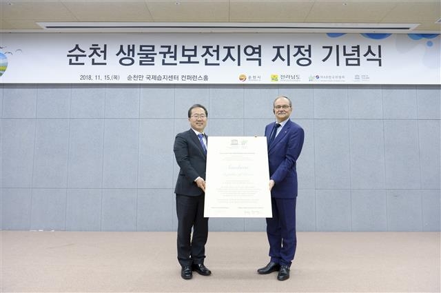 허석 순천시장이 2018년 순천만국제습지센터에서 미겔 클뤼세너고트 유네스코본부 생태지구과학국장으로부터 ‘순천 생물권보전지역 인증서’를 전달받고 있다. 순천시 제공