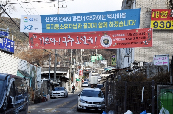 마을 입구에 걸려 있는 재개발 시행사의 현수막.