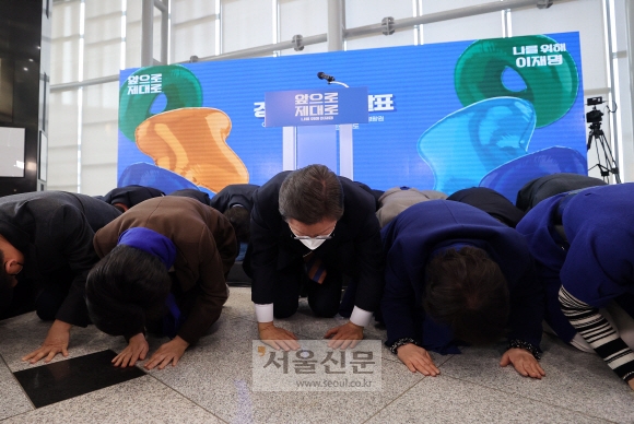 이재명 더불어민주당 대선 후보가 24일 오전 경기 용인 포은아트홀에서 경기도 정책 공약 발표에 앞서 경기도에 지역구를 둔 민주당 의원들과 함께 앞으로 더 잘하겠다는 뜻으로 큰절을 하고 있다. 2022. 1. 24 김명국 선임기자