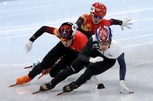 황대헌이 7일 중국 베이징 수도체육관에서 열린 쇼트트랙 남자 1000m 준결승에서 중국 런쯔웨이(54번)와 리원룽(94번)을 제치며 1위로 올라서고 있다. 황대헌은 이 과정에서 레인 변경이 늦었다는 이유로 페널티를 받아 결승 진출에 실패했다. 베이징 연합뉴스