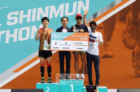 2022 서울신문 마라톤대회에서 곽태헌(왼쪽에서 두 번째) 서울신문사 사장과 10㎞ 코스 남자부 입상자인 김병조(2위·맨 왼쪽), 손기찬(1위), 강두희(3위)씨가 무대 위 시상대에서 트로피를 들고 기념촬영을 하고 있다. 오장환 기자
