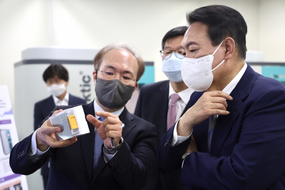 윤석열 대통령이 26일 충북 청주 국립보건연구원 바이오뱅크(국립중앙인체자원은행)를 방문해 반자동 추출기 앞에서 권준욱 국립보건연구원장의 설명을 듣고 있다. 2022.05.27 대통령실사진기자단