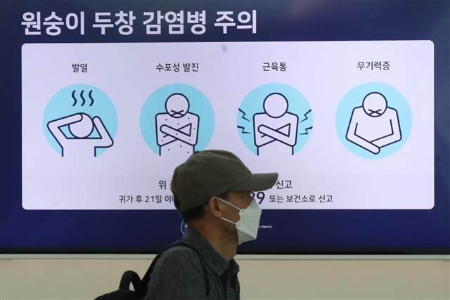 5일 인천국제공항 제1여객터미널 출국장 전광판에 표시된 원숭이두창 감염병 주의 안내문 앞을 한 시민이 지나가고 있다. 뉴스1