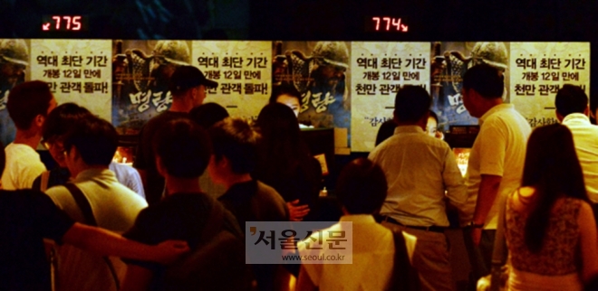 영화 ‘명량’이 역대 최단 기간 1000만 관객을 돌파한 10일 서울 용산구 한 영화관에서 관객들이 영화표를 구입하고 있다. 2014.08.10 박윤슬 기자