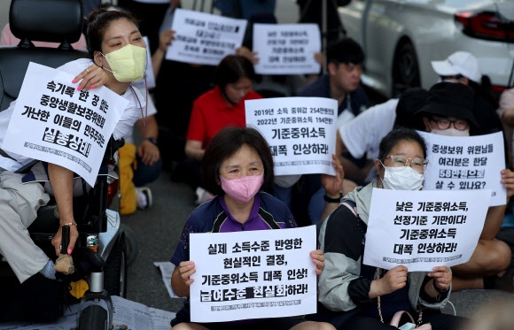 기초생활보장법 바로세우기 공동행동 등 시민단체 회원들이 지난 25일 정부세종청사 보건복지부 앞에서 생계 급여 등 정부 복지사업의 기준인 ‘중위소득’을 현실에 맞게 올려달라고 요구하고 있다. 연합뉴스