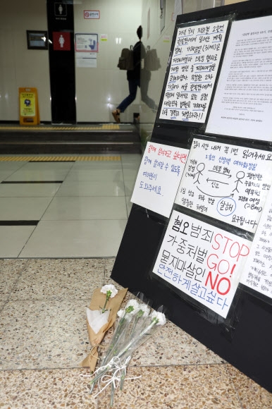 15일 오후 20대 여성 역무원 살인 사건이 발생한 서울 신당역 여자화장실 앞에 추모의 꽃과 혐오 범죄 중단을 촉구하는 글이 놓여 있다. 연합뉴스