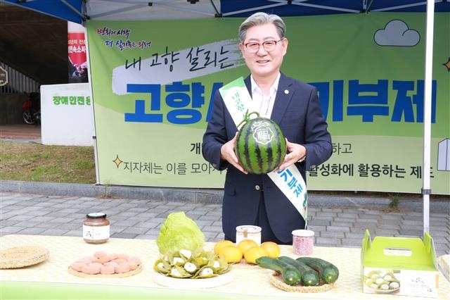 전국 243개 지방자치단체가 내년 시행될 고향사랑기부제 준비에 여념이 없다. 기존 귀농·귀촌 정책이 도시민의 물리적인 이주 정책을 의미했다면 고향사랑기부제는 도시민과 지역 간 기부를 통해 소통하는 ‘관계인구’를 형성시킬 정책으로 평가받는다. 오태완 경남 의령군수가 지난 9월 고향사랑기부금의 답례품으로 검토하는 특산물 가운데 하나인 수박을 들어 보이고 있다. 서울신문 DB