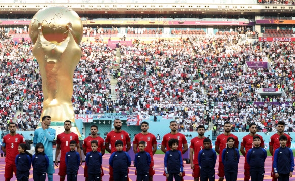 이란 축구대표팀 선수들이 21일(현지시간) 도하의 칼리파 경기장에서 잉글랜드와 카타르월드컵 조별리그 B조 1차전을 앞두고 국가 연주 때 입을 다물거나 허공을 응시하며 국가 제창을 거부하고 있다. 도하 AFP 연합뉴스
