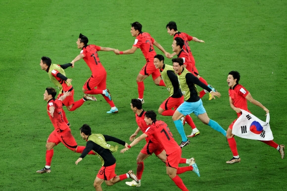 3일 오전(한국시간) 카타르 알라이얀의 에듀케이션 시티 스타디움에서 열린 2022 카타르 월드컵 조별리그 H조 3차전 대한민국과 포르투갈 경기. 16강 진출을 확정지은 선수들이 태극기를 휘날리며 환호하고 있다. 2022.12.3 연합뉴스