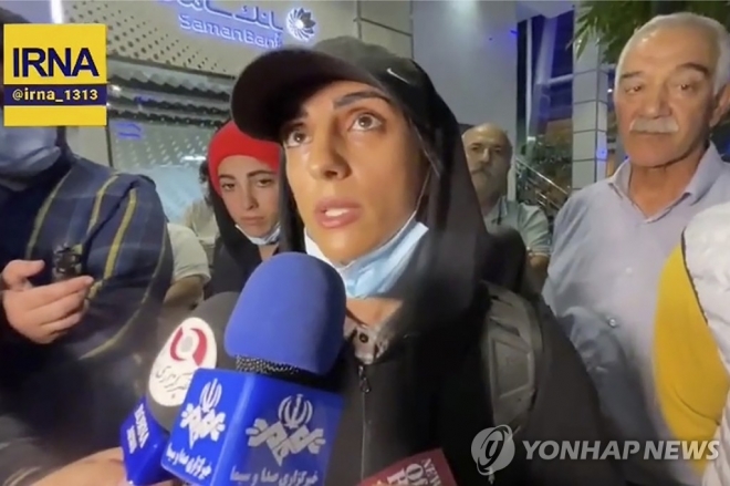 히잡을 쓰지 않고 서울에서 열린 스포츠클라이밍 대회에 출전했다가 실종의혹에 휩싸였던 이란 선수 엘나즈 레카비(33·가운데)가 지난달 19일(현지시간) 테헤란의 이맘 호메이니 국제공항에 도착해 기자들에게 귀국 소감을 밝히고 있다. 이란 국영 IRNA 통신 제공 비디오 캡처 자료사진 연합뉴스
