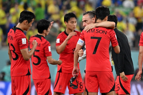 파울루 벤투(오른쪽 두 번째) 한국 축구 대표팀 감독이 6일 새벽(한국시간) 카타르 도하 스타디움 974에서 열린 2022 카타르월드컵 16강전에서 세계 최강 브라질에 1-4로 패한 뒤 손흥민 등 선수들을 위로하고 있다. 도하 AFP 연합뉴스