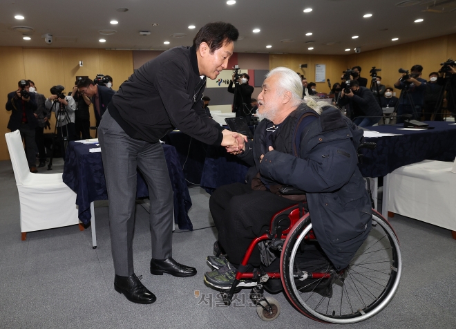 오세훈(왼쪽) 서울시장이 2일 시청에서 전국장애인차별철폐연대와의 간담회를 마친 뒤 전장연 박경석 대표와 악수하고 있다. 홍윤기 기자