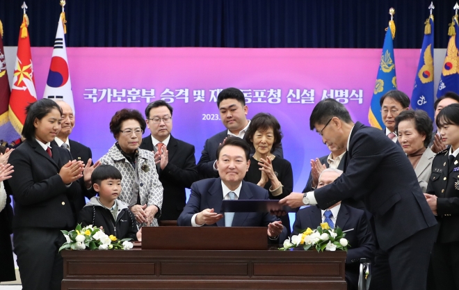윤석열 대통령이 2일 서울 용산구 대통령실 청사에서 국가보훈부 승격과 재외동포청 신설을 골자로 하는 ‘정부조직법’ 공포안에 서명하고 참석자들의 박수를 받고 있다. 이날 공포된 정부조직법에 따라 국가보훈처는 오는 6월 ‘부’로 격상되고 외교부 산하에 재외동포청이 신설된다. 서명식에는 유공자 예우 차원에서 국가를 위해 희생한 이들과 유가족이 초대됐다. 연합뉴스