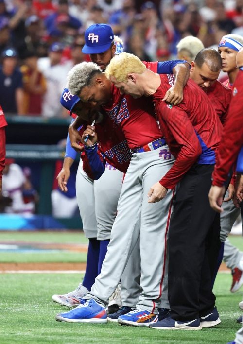 푸에르토리코의 에드윈 디아스가 16일 WBC 1라운드 D조 최종전에서 도미니카공화국을 꺾은 뒤 승리 세리머니를 하다 무릎을 다쳐 부축을 받으며 그라운드를 떠나고 있다 . AFP 연합뉴스