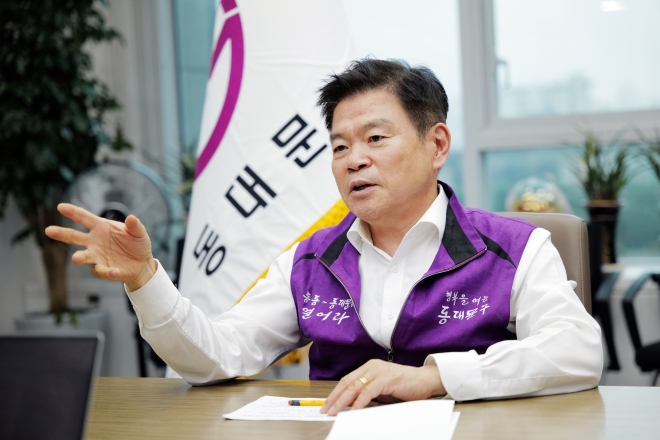 이필형 서울 동대문구청장이 26일 구청 집무실에서 서울신문과 인터뷰하고 있다. 동대문구의 새로운 상징색인 퍼플(보라색) 조끼를 입은 이 구청장은 동대문구의 8개 전통시장을 하나로 통합 개발해 글로벌 톱 5 시장으로 만들겠다고 밝혔다. 동대문구 제공