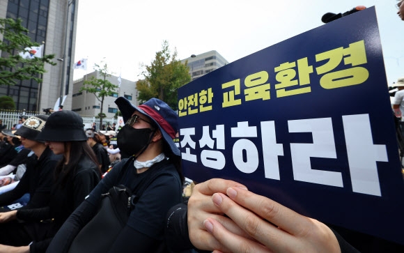 전국 각지에서 모인 교사들이 서울 종로구 경복궁역 사거리 인근에서 열린 공교육 정상화를 위한 집회에 참석해 팻말을 들고 있다. 2023.7.29 연합뉴스