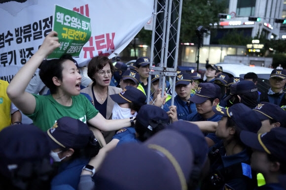 한 활동가가 22일 저녁 서울시청 앞에서 일본방사성오염수 해양 투기 저지 공동행동이 주최한 집회 도중 일본 정부가 방류 계획을 철회할 것을 요구하는 구호를 외치고 있다. 서울 AP 연합뉴스