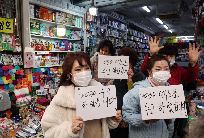 윤석열 대통령의 방문을 앞두고 6일 부산 중구 깡통시장에서 부산 시민들이 윤 대통령의 부산엑스포 유치활동에 대한 감사 메시지를 보여주며 환영하고 있다. 2023.12.6 연합뉴스