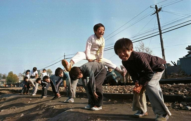 1979년 서울의 한 기찻길 옆에서 등넘기를 하며 해맑게 웃는 아이들. 서울신문의 흑백사진을 컬러로 복원했다. 서울신문 DB