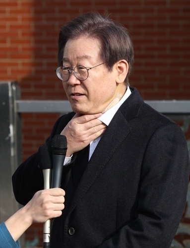 목 만지며 발언하는 이재명 대표