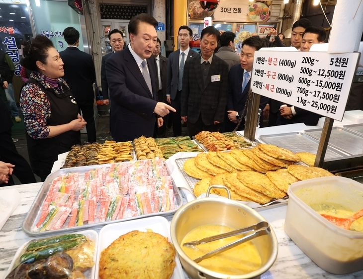 윤석열 대통령이 설 명절을 앞둔 8일 서울 광진구 중곡제일시장에서 전을 사고 있다. 윤 대통령은 앞서 열린 민생토론회에서 소상공인·자영업자를 위한 정책을 발표했다. 대통령실통신사진기자단