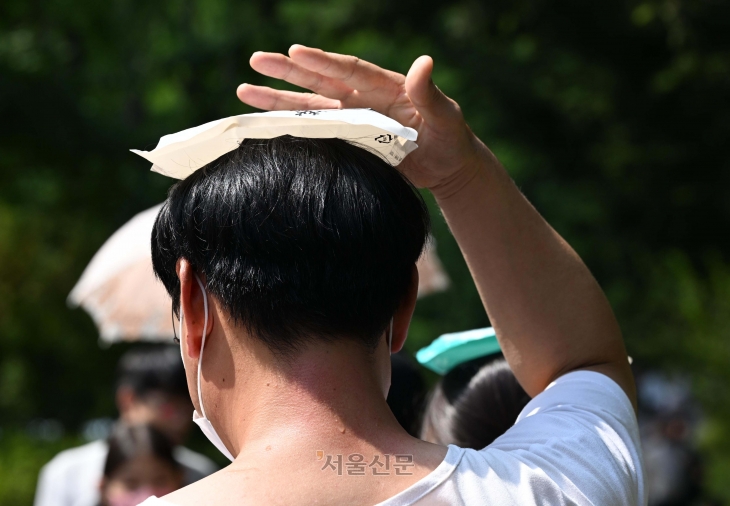 지난 8월 서울 서대문구 서대문형무소역사관을 찾은 시민들이 폭염에 아이스팩을 머리에 올리고 있다. 도준석 기자