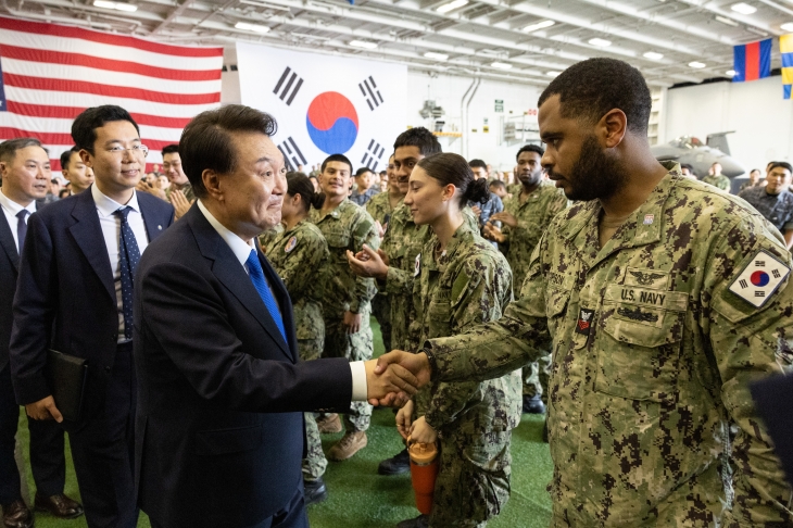 윤석열 대통령이 25일 부산 해군작전기지에서 미 해군 항공모함 시어도어 루즈벨트함에 승선해 발언 뒤 한미 장병들과 인사하며 이동하고 있다. 2024.6.25 대통령실 제공